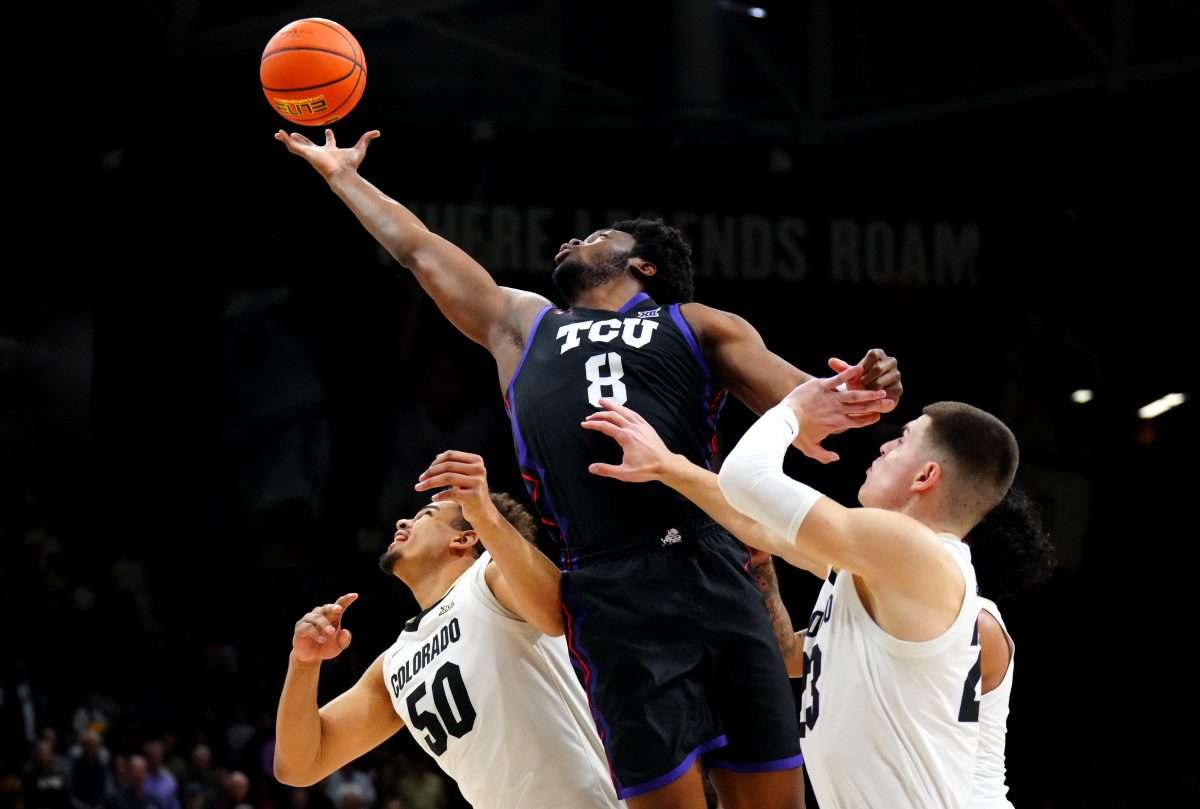 Mar 8, 2025; Boulder, Colorado, USA; TCU Horned Frogs center Ernest Udeh Jr. (8) reaches for a rebound over Colorado Buffaloes forward Andrej Jakimovski (23) and center Elijah Malone (50) in the first half at the CU Events Center. Mandatory Credit: Ron Chenoy-Imagn Images